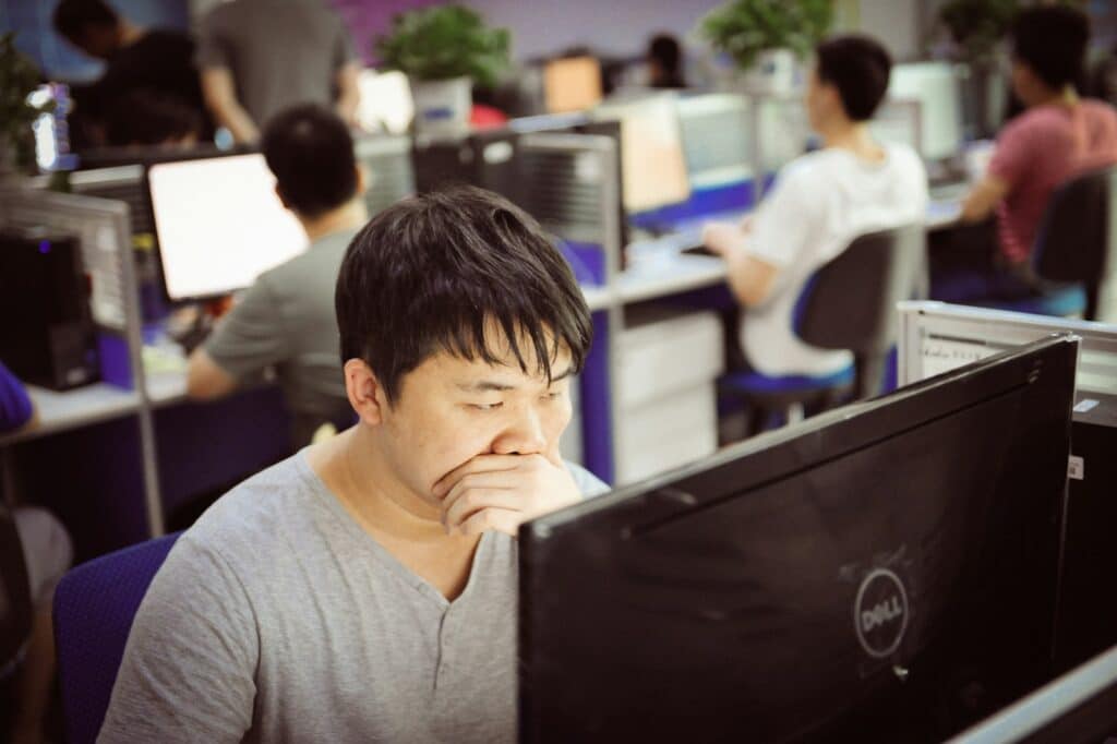 Man yawning while working at computer in office