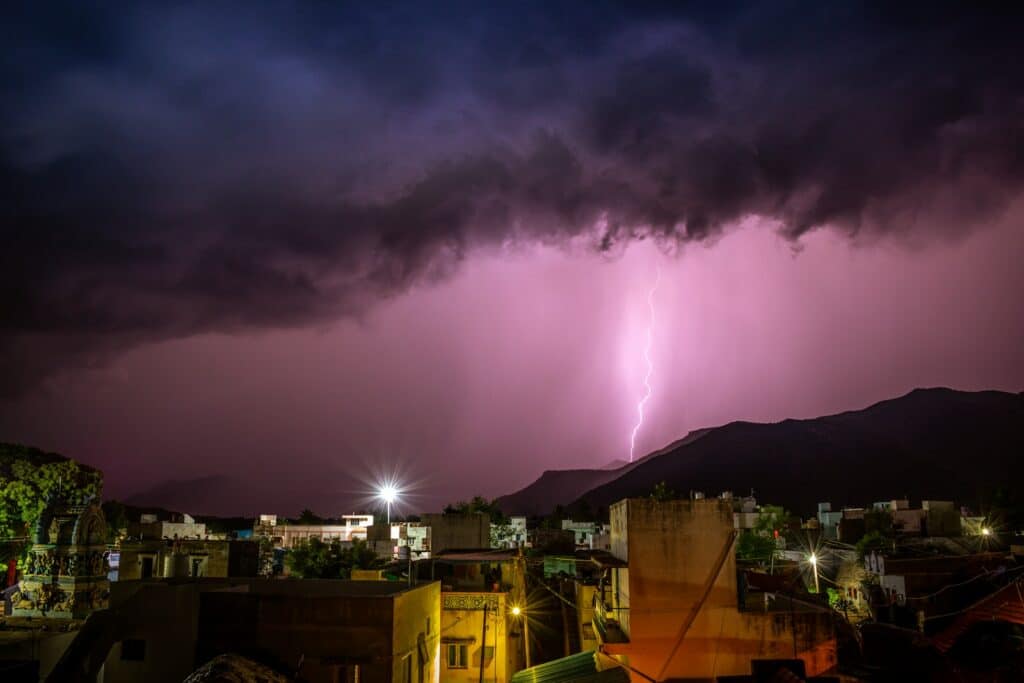 a lightning bolt hitting over a city at night