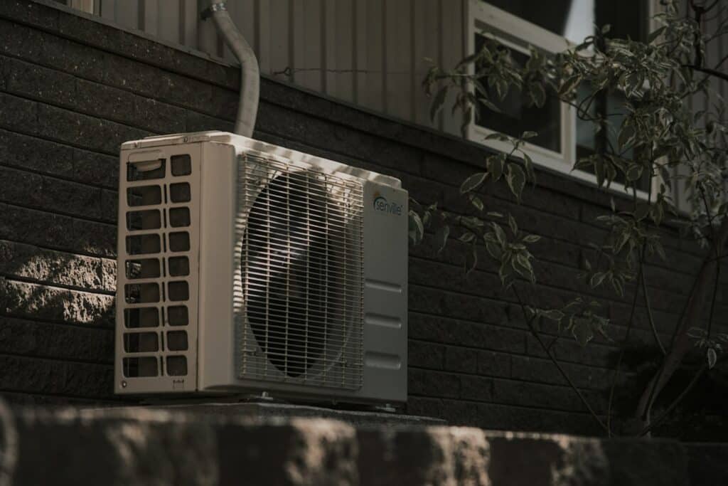 a white air conditioner sitting on top of a brick wall