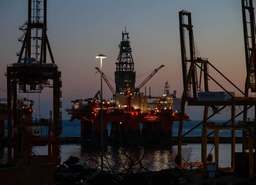 The West Bollsta semi-submersible drilling rig docked in a harbor at low light